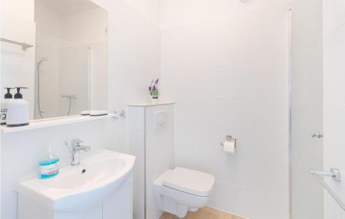 a white bathroom with a toilet and a sink at Nice Home In Jaroslawiec With Kitchen in Jarosławiec