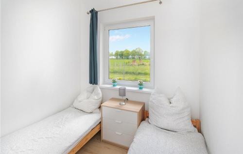 a bedroom with two beds and a window at Nice Home In Jaroslawiec With Kitchen in Jarosławiec
