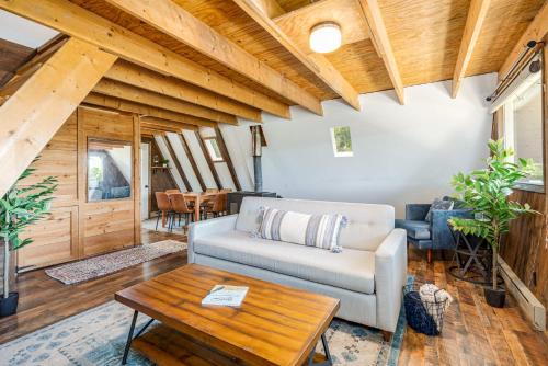 a living room with a couch and a table at Great Views! A-Frame w Hot Tub, Grill & Fire Pit in Morton Grove