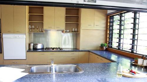 una cocina con fregadero y encimera en Picnic House, Luxurious Tropical House, en Picnic Bay