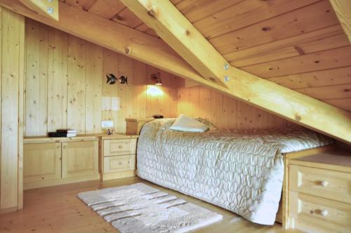 1 dormitorio con 1 cama en el techo de madera en BelaVal Apartments, en La Villa