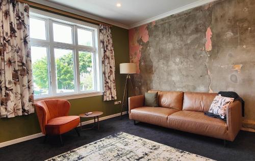a living room with a couch and a window at Historic Inner City Apartment in Invercargill