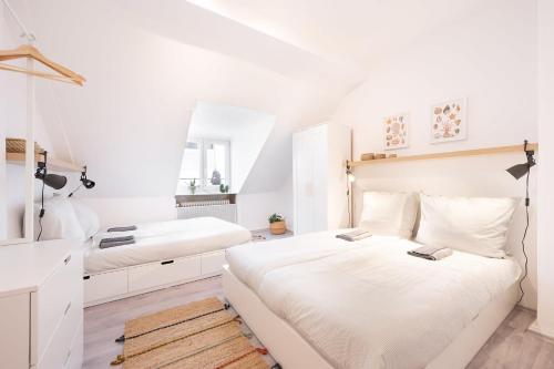 a white bedroom with two beds and a mirror at 131 Schaefflerstr in Munich