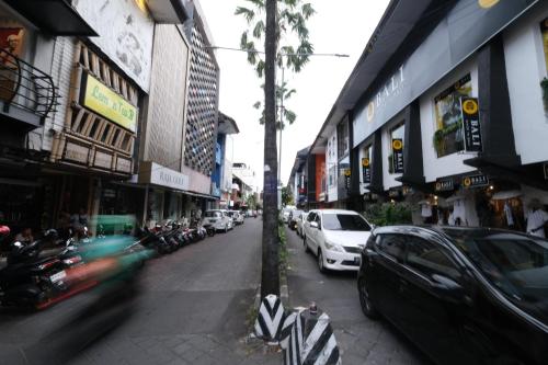 a busy city street with cars parked on the street at Zia Hotel Kuta in Kuta