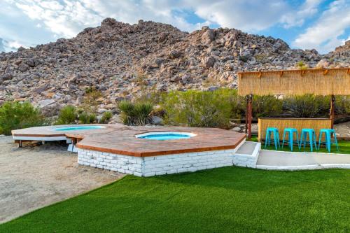 a backyard with a patio with a table and chairs at Neon Moon An Elevated Experience w Pool and Spa in Joshua Tree