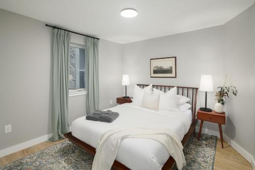 a white bedroom with a large bed and a window at 2BR in Heart of Queen Village - walk to everything! in Philadelphia