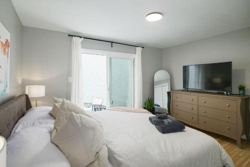 a bedroom with a bed with a television and a dresser at 2BR in Heart of Queen Village - walk to everything! in Philadelphia