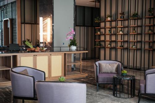 a lobby with chairs and a counter and shelves with plants at FLC City Hotel Beach Quy Nhon in Quy Nhon