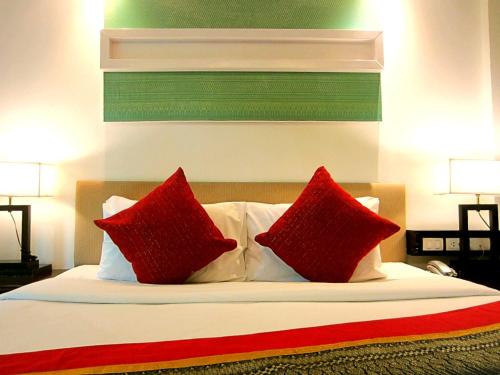 a bedroom with a bed with red pillows at Yantarasri Resort in Chiang Mai