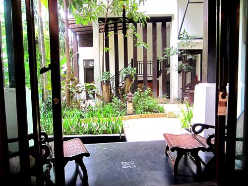 two benches sitting on a table in front of a building at Yantarasri Resort in Chiang Mai