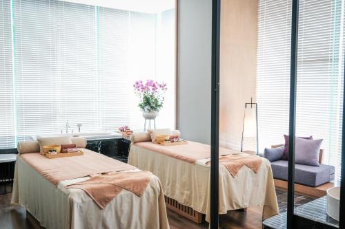 a room with two beds and a vase of flowers at FLC City Hotel Beach Quy Nhon in Quy Nhon