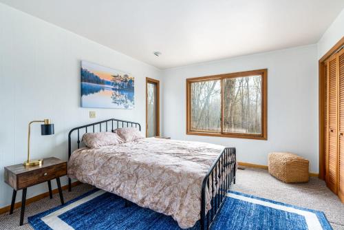 a bedroom with a bed and a table and a window at Hot Tub, Big Deck, Comm Pool, WiFi at Chalet Cabin in Berkeley Springs