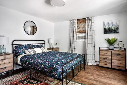 um quarto com uma cama, uma cómoda e um espelho em Chalet Cabin w Hot Tub Deck Grill Fire Pit WiFi em Morton Grove