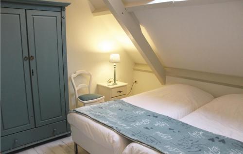 a bedroom with a bed and a chair and a lamp at Vrij-Uitzicht in Slootdorp