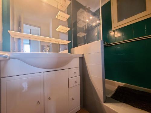 baño con lavabo blanco y pared verde en Maison Argelès-sur-Mer, 3 pièces, 5 personnes - FR-1-309-273, en Argelès-sur-Mer