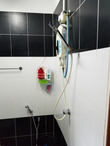 łazienkę z prysznicem wyłożoną czarno-białymi kafelkami. w obiekcie Impiana homestay langkawi w mieście Pantai Cenang