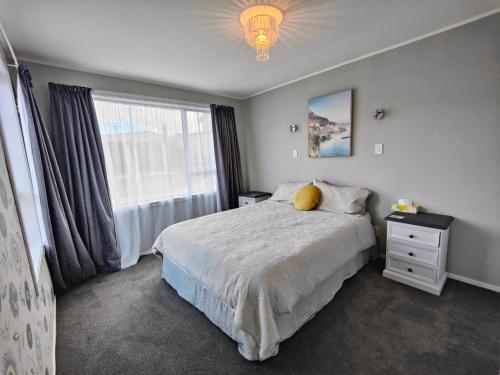 een slaapkamer met een bed met een geel kussen en een raam bij A Family Favourite! in Riverton