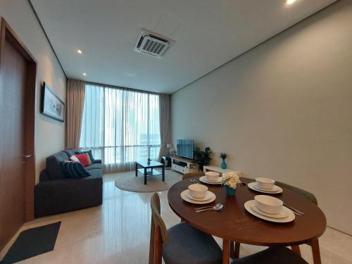 een woonkamer met een tafel en een bank bij Inspired Homes @ KLCC Soho Suite in Kuala Lumpur