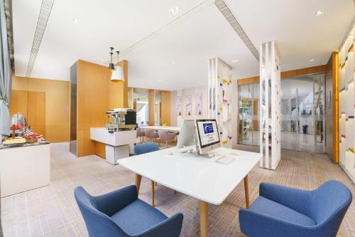 an office with a white table and blue chairs at Holiday Inn Express City Centre Dalian, an IHG Hotel in Dalian