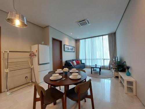 een keuken en woonkamer met een tafel en stoelen bij Inspired Homes @ KLCC Soho Suite in Kuala Lumpur