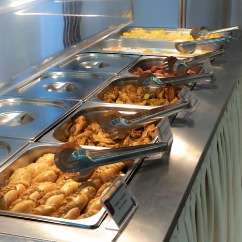 a buffet line with many trays of food at Jumbaktas Astana Hotel in Astana