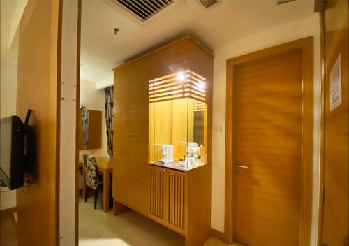 a hallway with a wooden cabinet in a room at Crown Garden Hotel in Kota Bharu