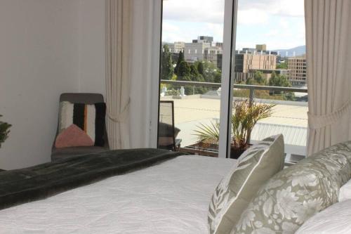 1 dormitorio con cama y ventana grande en Battery Point Apartment on Hampden, en Hobart
