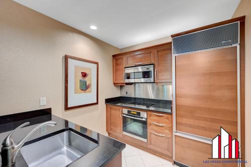 a kitchen with wooden cabinets and a stainless steel appliances at MGM Signature-03-821 1Br2Ba F1 Strip View Balcony in Las Vegas
