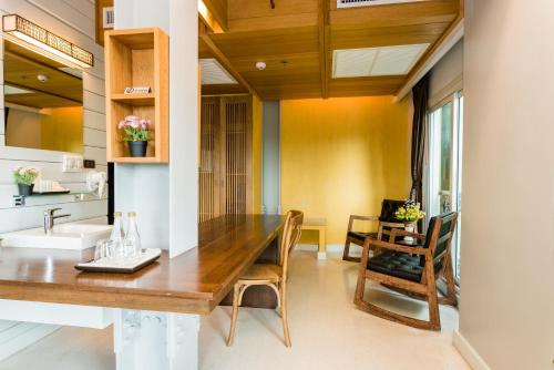 a dining room with a wooden table and chairs at Dang Derm In The Park Khaosan in Bangkok