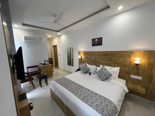 a hotel room with a bed and a television at Click Collection The Abode, Dharamshala in Dharamshala