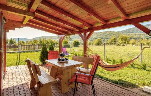 eine Terrasse mit einem Tisch, Stühlen und einer Hängematte in der Unterkunft Gorgeous Home In Licko Lesce in Ličko Lešće