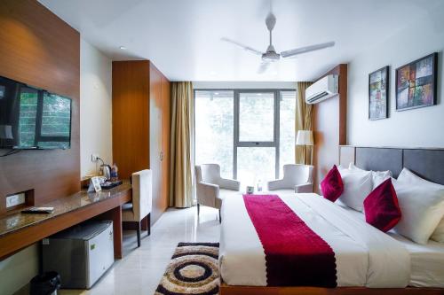 a hotel room with a large bed and a desk at Saltstayz Grand Sky - Unitech Cyber Park in Gurgaon