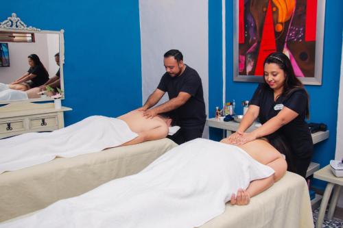 un hombre y una mujer recibiendo un masaje estomacal en Hotel Marionetas en Mérida
