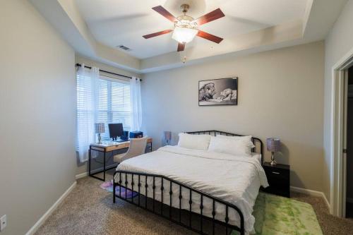 una camera con letto, ventilatore a soffitto e scrivania di An Exquisite 3 BedroomTownhome in Zionsville a Zionsville