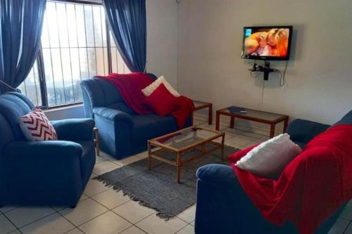 - un salon avec 2 chaises bleues et une télévision dans l'établissement Villa Del Sol Unit 8, à Margate