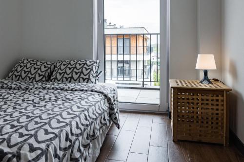 een slaapkamer met een bed en een groot raam bij ENERGYLANDIA Zator Apartament Krzyś in Zator