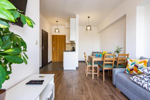 een woonkamer en een keuken met een blauwe bank en een tafel bij ENERGYLANDIA Zator Apartament Krzyś in Zator