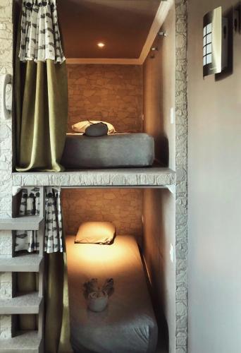 two bunk beds in a room with a curtain at La Zona Hostel in San Salvador