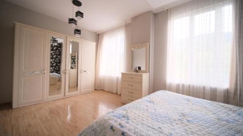 a bedroom with a bed and a dresser and a mirror at Guesthouse - Family Hotel in Bagdatʼi
