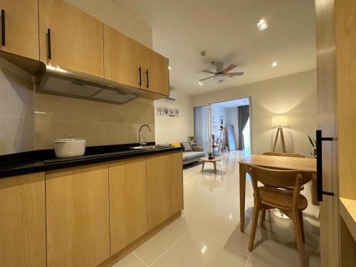 a kitchen with wooden cabinets and a table in a room at THE SHORE SEAVIEW Centre Of The City in Kota Kinabalu