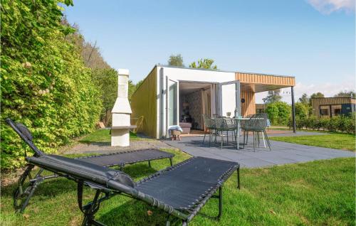 a bench in the grass next to a house at Nice Home In Heinkenszand With Sauna in Heinkensand