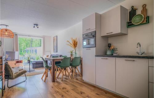 a kitchen with a table and chairs in a room at Nice Home In Heinkenszand With Sauna in Heinkensand