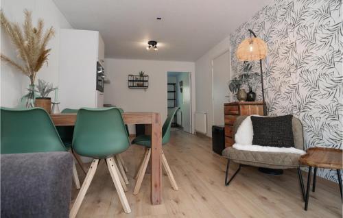 a dining room with a wooden table and green chairs at Nice Home In Heinkenszand With Sauna in Heinkensand