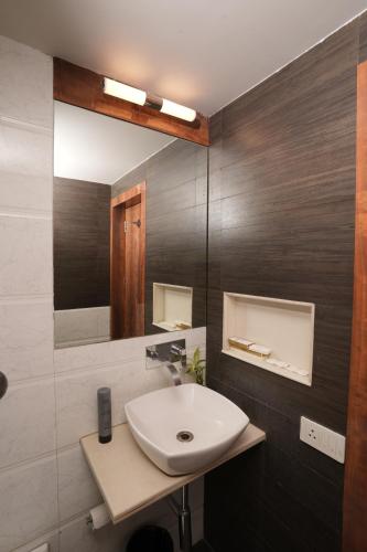 a bathroom with a sink and a mirror at Hotel Hardeo in Nagpur