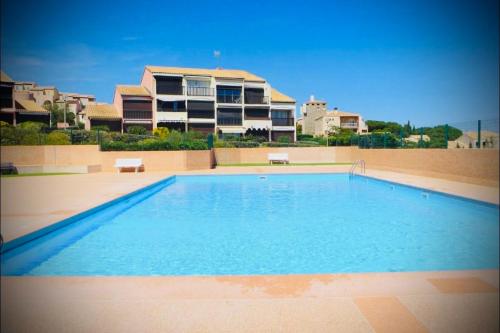 une grande piscine devant un immeuble dans l'établissement La maison du bonheur les eaux vives 1, à Saint Pierre La Mer
