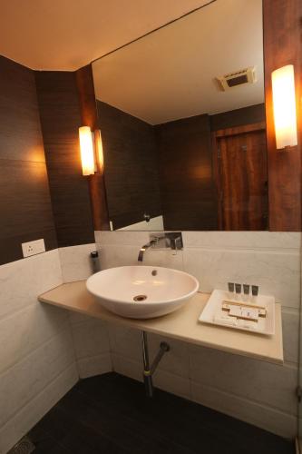 a bathroom with a white sink and a mirror at Hotel Hardeo in Nagpur