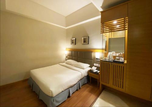 a bedroom with a large bed and a mirror at Crown Garden Hotel in Kota Bharu