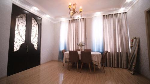 comedor con mesa, sillas y lámpara de araña en Guesthouse - Family Hotel, en Bagdatʼi