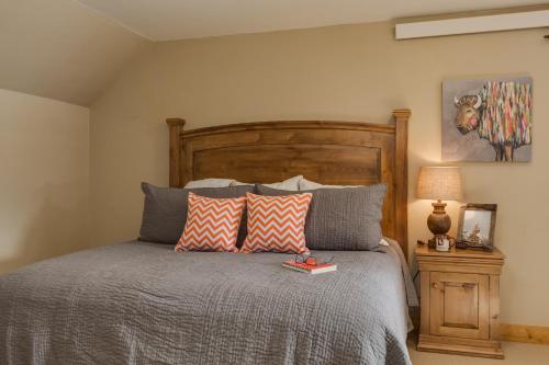 a bedroom with a bed with a wooden headboard and pillows at Alpine Airspace by KABINO Airpark Foosball Garage Satellite in Alpine