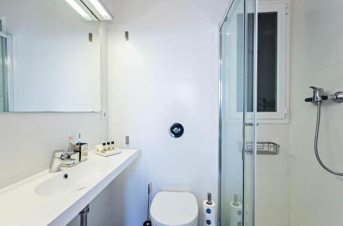 uma casa de banho com um WC e uma cabina de duche em vidro. em Sweet Inn - Atic Gracia em Barcelona